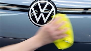 Ein Mitarbeiter von Volkswagen streicht mit einem Tuch über ein Fahrzeug von VW.