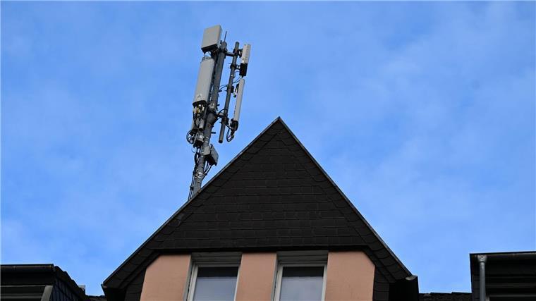 Behörde will auf Handynetz-Auktion verzichten Ein Mobilfunk-Mast mit Antennen im Funkstandard 5G (quadratisch) und 4G (länglich) ist auf dem Dach eines Wohnhauses montiert.