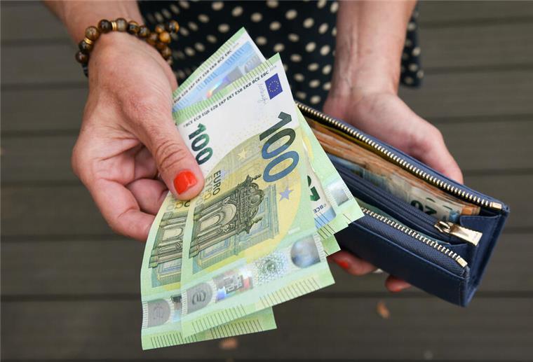 Eine Frau hält eine mit mehreren Geldscheinen gefüllte Geldbörse in einer Hand. Ein neuer Mega-Zuschuss soll Familien von Pflegebedürftigen entlasten. Bis zu 1800 Euro monatlich sind möglich.