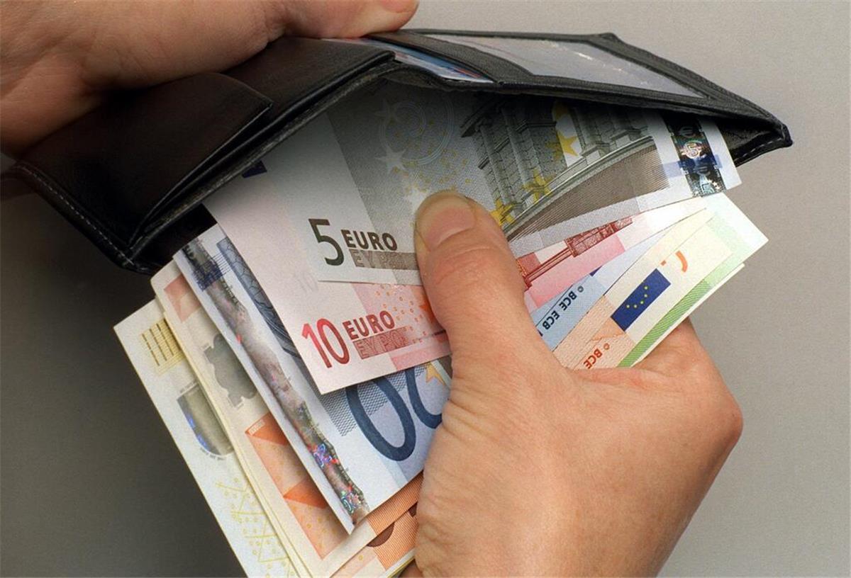 Durchgesickert: Merz-Regierung plant Mega-Entlastung für Bürger - Bis zu 220 Euro möglich Ein Mann verstaut einige Euro-Geldscheine in seiner Geldbörse.