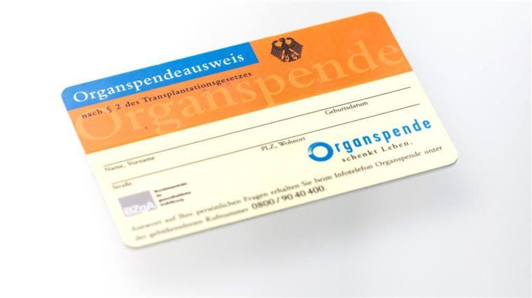 Ein Organspendeausweis spiegelt sich in einem Glastisch.