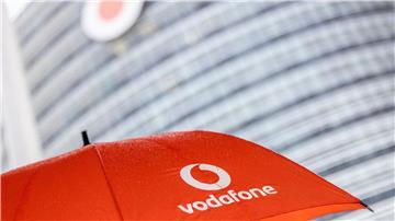 Ein Passant geht mit einem aufgespanntem Regenschirm mit dem Logo von Vodafone an der Zentrale der Deutschlandtochter des britischen Vodafone-Konzerns vorbei.