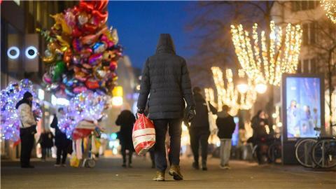 Ein Passant läuft mit einer Einkaufstasch durch die Innenstadt.