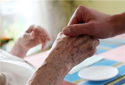 Ein Pfleger hält in einem Pflegeheim die Hand einer Bewohnerin. Wenn es nach einer Mehrheit der Deutschen geht, sollen bald alle Jugendlichen ein Pflichtjahr im sozialen Bereich absolvieren.