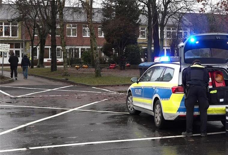 Ein Polizeiauto steht vor dem Gebäude einer Grund- und Hauptschule in Lüdingworth. Dort hat ein Mädchen ein anderes mit einem Messer schwer verletzt.