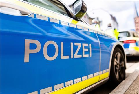 Zwei Einsatzfahrzeuge der Polizei stehen in Freiburg am Straßenrand.