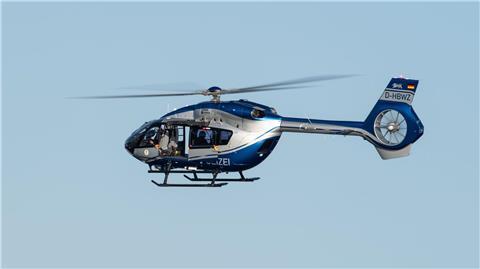Ein Polizeihubschrauber fliegt im Rahmen eines Trainings über ein Gewässer.