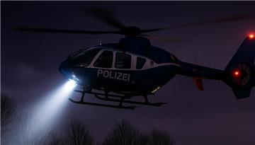 Ein Polizeihubschrauber mit einem Suchscheinwerfer in der Dunkelheit (Symbolbild).