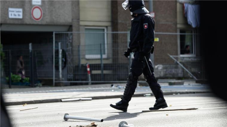 Illegale Abriegelung von Wohnblock: Schmerzensgeldforderung Ein Polizist geht an Metall- und Holzgegenständen vorbei, die vor einem unter Quarantäne gestellten Wohngebäude in der Göttinger Innenstadt auf dem Boden liegen.