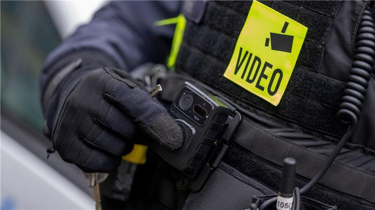 IS-Razzia: Drei Wohnungen in Niedersachsen durchsucht Ein Polizist schaltet die Bodycam auf seiner Uniform ein.