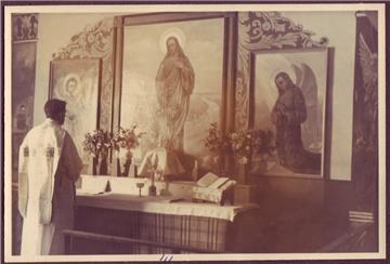 Ein Priester steht vor einem Altar im Kriegsgefangenenlager Sandbostel
