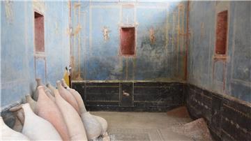 Ein Raum mit blauen Wänden und gemalten weiblichen Figuren ist in Pompeji freigelegt worden.