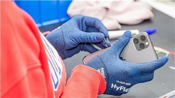 Ein Rebuy-Beschäftigter macht ein gebrauchtes iPhone flott, damit es verkauft werden kann.