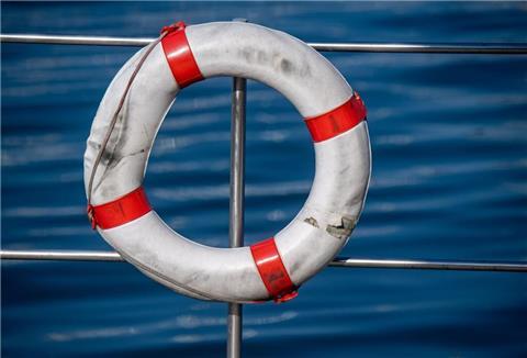 Ein Rettungsring hängt am Seezaun eines Hausboot ist in einem Hafen an der Ostsee.