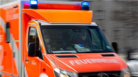 Ein Rettungswagen der Feuerwehr fährt auf einer Straße.