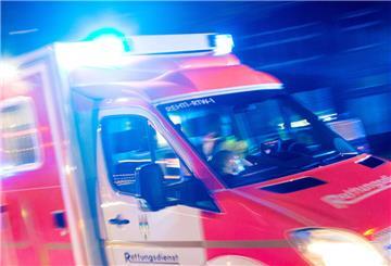Ein Rettungswagen der Feuerwehr fährt mit Blaulicht durch eine Straße.