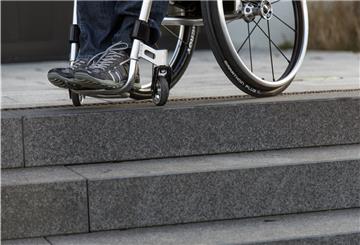 Ein Rollstuhlfahrer sitzt in seinem Rollstuhl an einer Treppe zu einem Rathaus. Während der Pandemie kam und kommt die Mobilität vieler Behinderter zum Erliegen, hieß es bei einer Sitzung des Behindertenbeirates am Donnerstagnachmittag im Kreishaus.