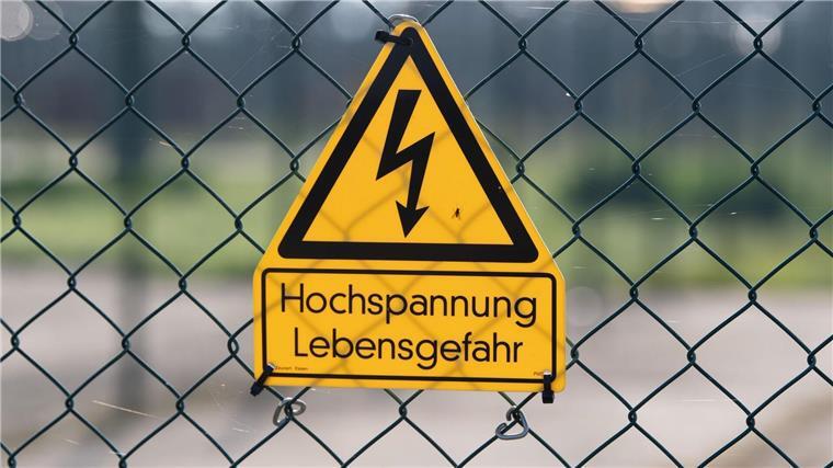 Ein Schild an einem Zaun warnt vor Hochspannung