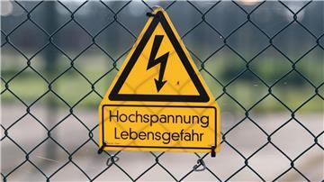 Ein Schild an einem Zaun warnt vor Hochspannung
