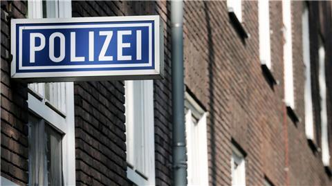 Ein Schild mit der Aufschrift „Polizei“ hängt an einem Polizeipräsidium.