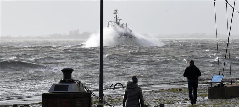 Ein Schlepper stampft auf der Weser gegen die Wellen an: Ein spektakuläres Schauspiel für die Bremerhavener, die sich auf dem Deich mit Wonne durchpusten ließen. 