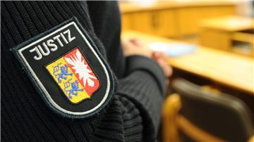 Ein schleswig-holsteinischer Justizbeamter steht im Landgericht im Sitzungssaal.