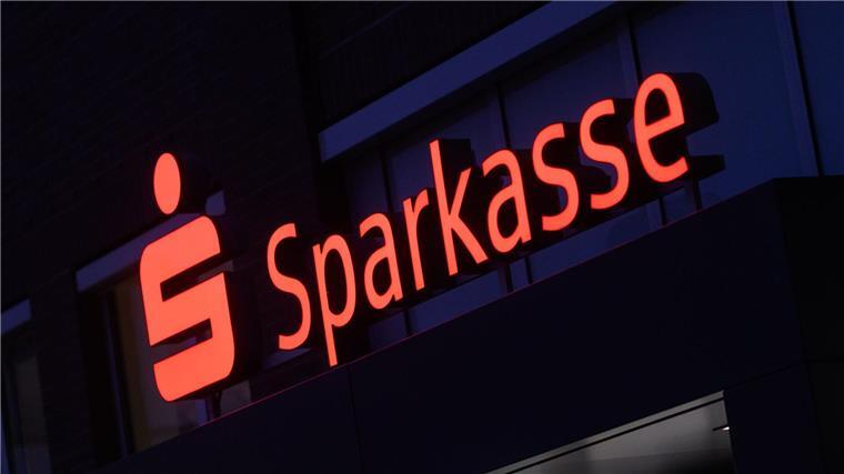 Ein Schriftzug der Sparkasse leuchtet an einer Filiale in der Region Hannover.