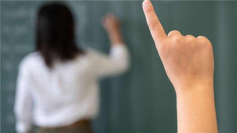 Niedersächsische Lehrkräfte: Startchancen-Programm richtig Ein Schüler meldet sich, während die Lehrerin an die Tafel schreibt.