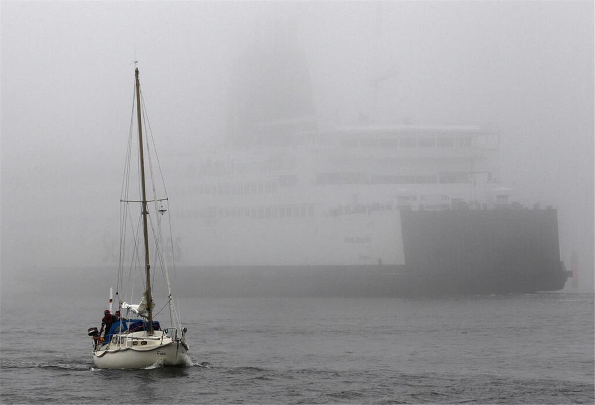 Geister-Nebel auf der Nordsee: Badegäste in Gefahr! Ein Segelschiff und ein Containerschiff auf der Nordsee.