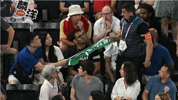 Ein Sicherheitsmann entfernt ein Transparent mit der Aufschrift „Taiwan“ beim Badminton.