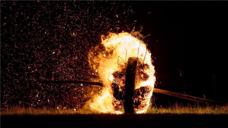 Spektakel in Lügde: Osterräderlauf an der Landesgrenze Ein sogenanntes Osterrad läuft, hier im vergangenen Jahr, brennend einen Hügel herunter und zieht eine Feuerspur hinter sich her. (Archivbild)