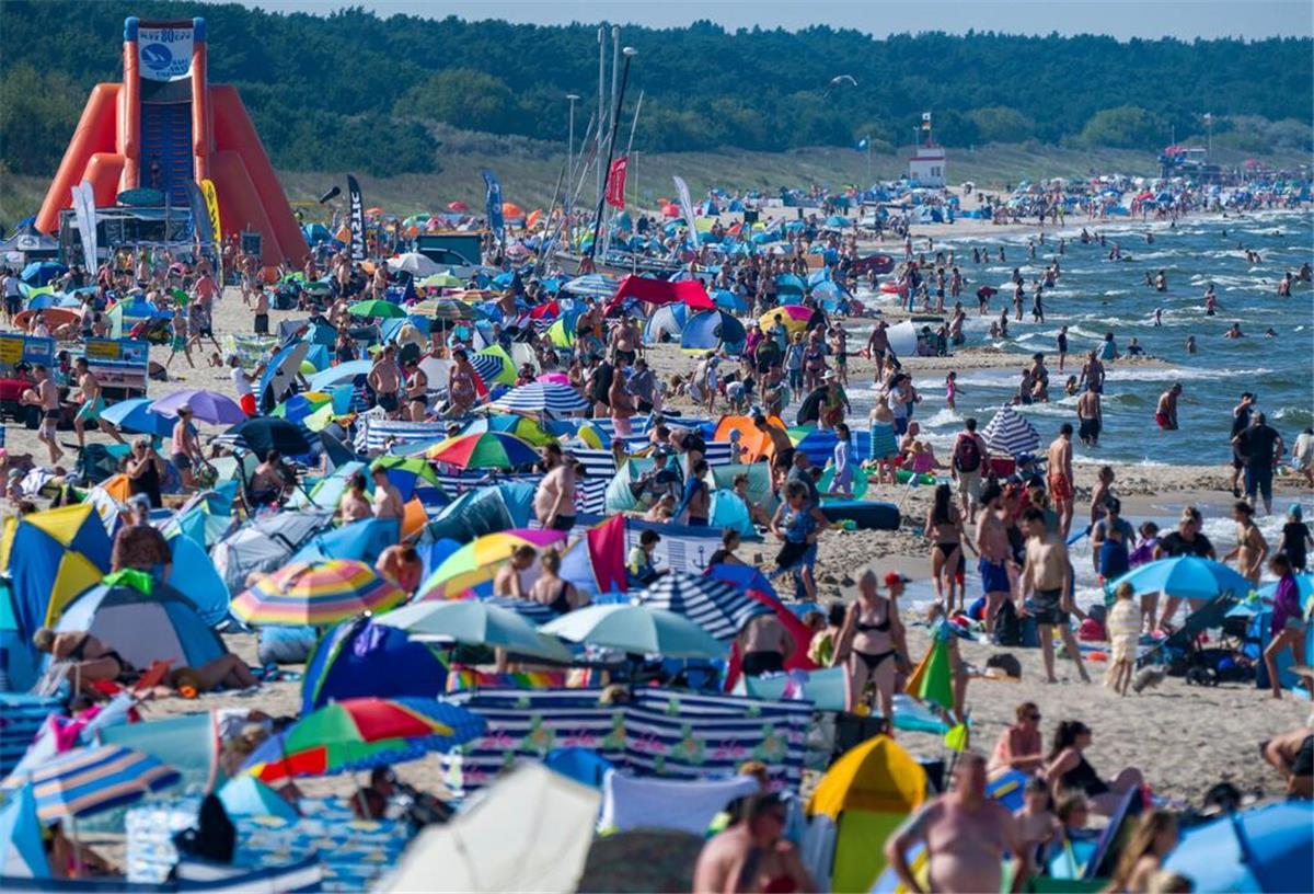 Urlaubsschock am Strand! Hier kosten Liege und Schirm bis zu 120 Euro Touristen halten sich bei Sonne und hochsommerlichen Temperaturen im Ostseebad am Strand und im Wasser auf.
