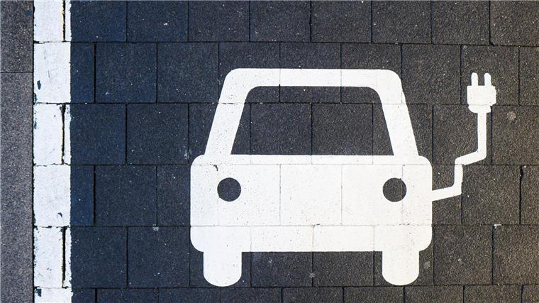 Ein Symbol markiert einen Parkplatz an einer Ladesäule für Elektroautos.