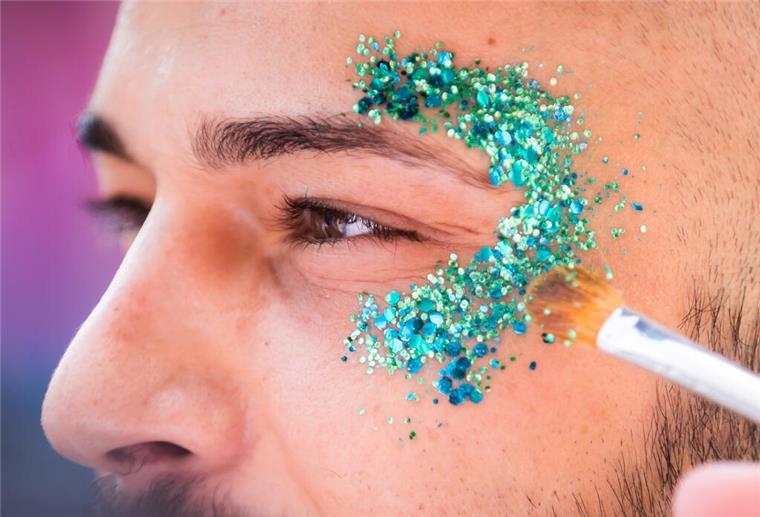 Glitzer-Verbot durch die EU? Deswegen sind gerade viele Drogerie-Regale leer Ein Teilnehmer lässt sich beim Christopher Street Day (CSD) Glitzer auftragen. Bald Vergangenheit?