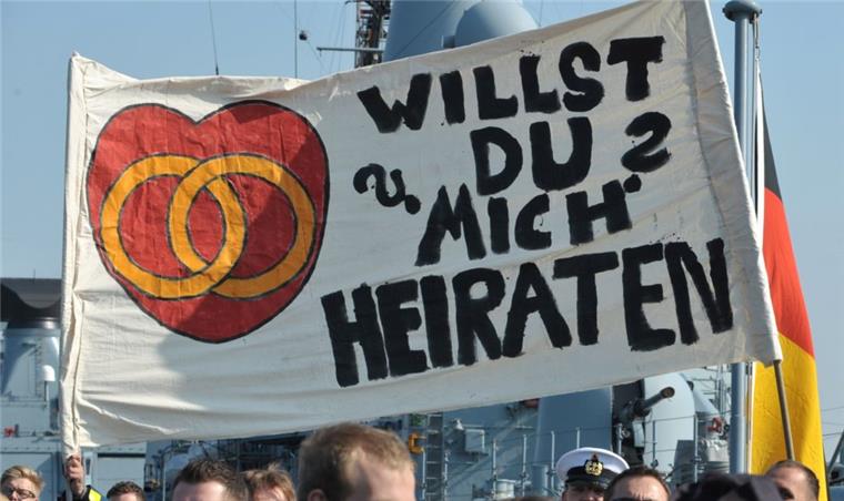 Ein Transparent mit einem Heiratsantrag wird am Freitag auf dem Deck einer Fregatte im Marinestützpunkt Wilhelmshaven hochgehalten. 