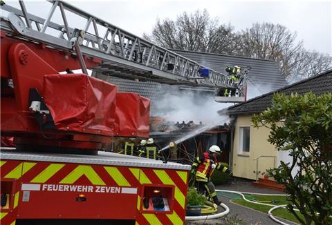 Feuerwehrleute löschen ein Feuer im Stuhmer Weg