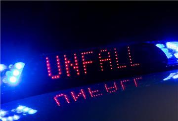 Das Blaulicht auf einem Fahrzeug der Polizei leuchtet in der Dunkelheit, während auf dem Display der Hinweis «Unfall» zu lesen ist.