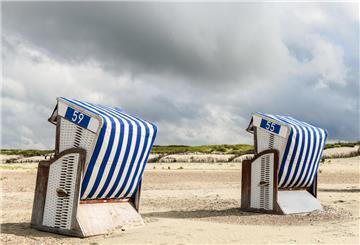 Drei Strandkörbe am Sandstrand unter bewölktem Himmel auf der Insel Norderney am 2. Juli 2020. ...Zum KNA-Text "Hasso Spodes Reise durch die Geschichte des Tourismus"