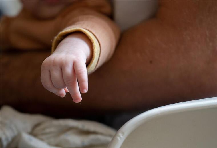 Ein Vater trägt seine Tochter auf dem Arm.