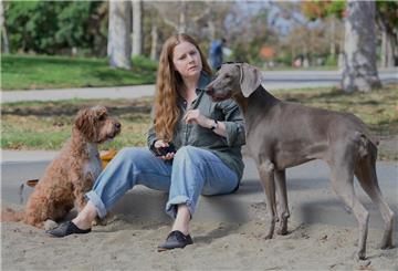 Eine Frau mit zwei Hunden.  Ein Vorstadthund auf zwei Beinen – „Nightbitch“ mit Amy Adams in der Hauptrolle zeigt, wie Mutterschaft zur tierischen Grenzerfahrung zwischen Selbstaufgabe, Instinkt und Identität werden kann.