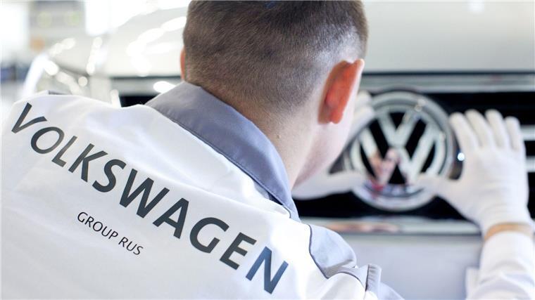 Ein VW-Mitarbeiter säubert im Volkswagenwerk im russischen Kaluga das Logo eines Volkswagen-Fahrzeug vom Modell Tiguan.