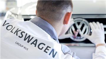 Ein VW-Mitarbeiter säubert im Volkswagenwerk im russischen Kaluga das Logo eines Volkswagen-Fahrzeug vom Modell Tiguan.