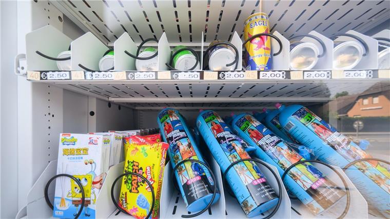 Ein Warenautomat, unter anderem mit Lachgasflaschen bestückt, steht vor einem Ladengeschäft.
