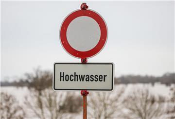 Ein Warnschild steht vor dem Hochwasser der Weser in Achim-Baden. (Symbolbild)