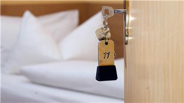 Ein Zimmerschlüssel hängt am 28.11.2014 in einem Gästehaus vor einem Bett im Türschloss.