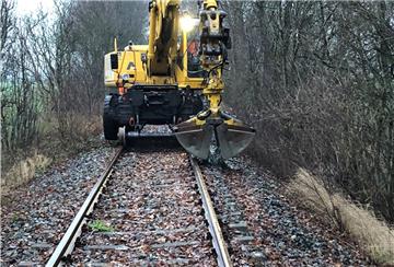 Ein Zweiwegebagger verteilt den Schotter auf der Bahnstrecke zwischen Bad Bederkesa und Drangstedt.