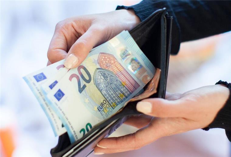 Hier wirds richtig teuer! Bürgergeldempfänger zahlen bis zu 147 Euro drauf Eine Person hält 20-Euro-Scheine aus ihrer Geldbörse in die Kamera.