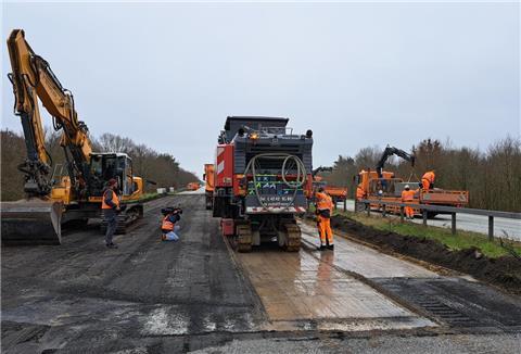 Eine Asphaltfräse trägt die Asphalt- und Betonschichten auf der A27 über dem maroden Grabendurchlass ab. 