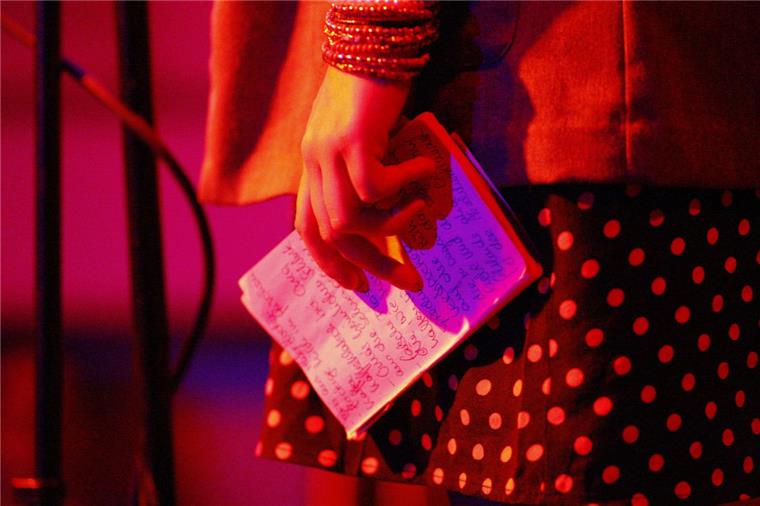Poetry Slam: Mutige Dichter bereiten sich bei Workshop in Tarmstedt vor Eine Autorin hält bei einem Poetry Slam ihre Notizen in der Hand. Am 24. Juni werden Dichter in Tarmstedt versuchen, das Publikum mit guten Texten und mitreißender Performance für sich einzunehmen.