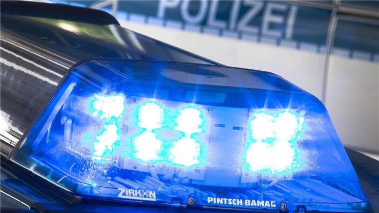 Eine Blaulicht leuchtet auf dem Dach eines Polizeiwagens. Im Hintergrund steht ein weiterer Streifenwagen.